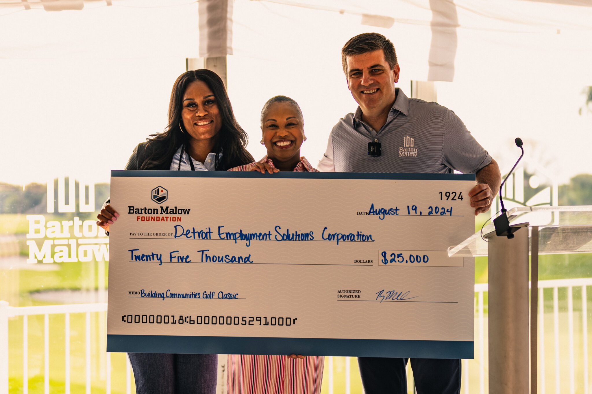 Barton Malow President +CEO Ryan Maibach presents the Detroit Employment Solutions Corporation a check at the Golf Classic